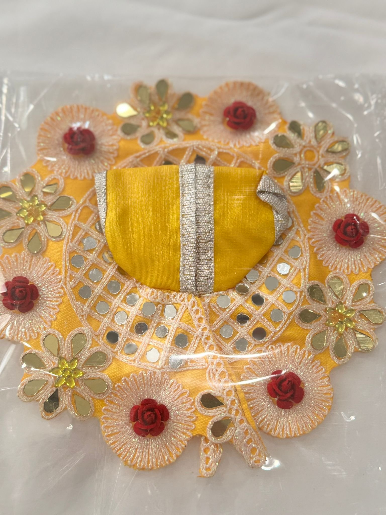 Size 3 Laddu Gopal dress in vibrant yellow with mirror work, red rose embellishments, floral lace border, and silver gota patti — perfect festive attire for Bal Gopal idol."