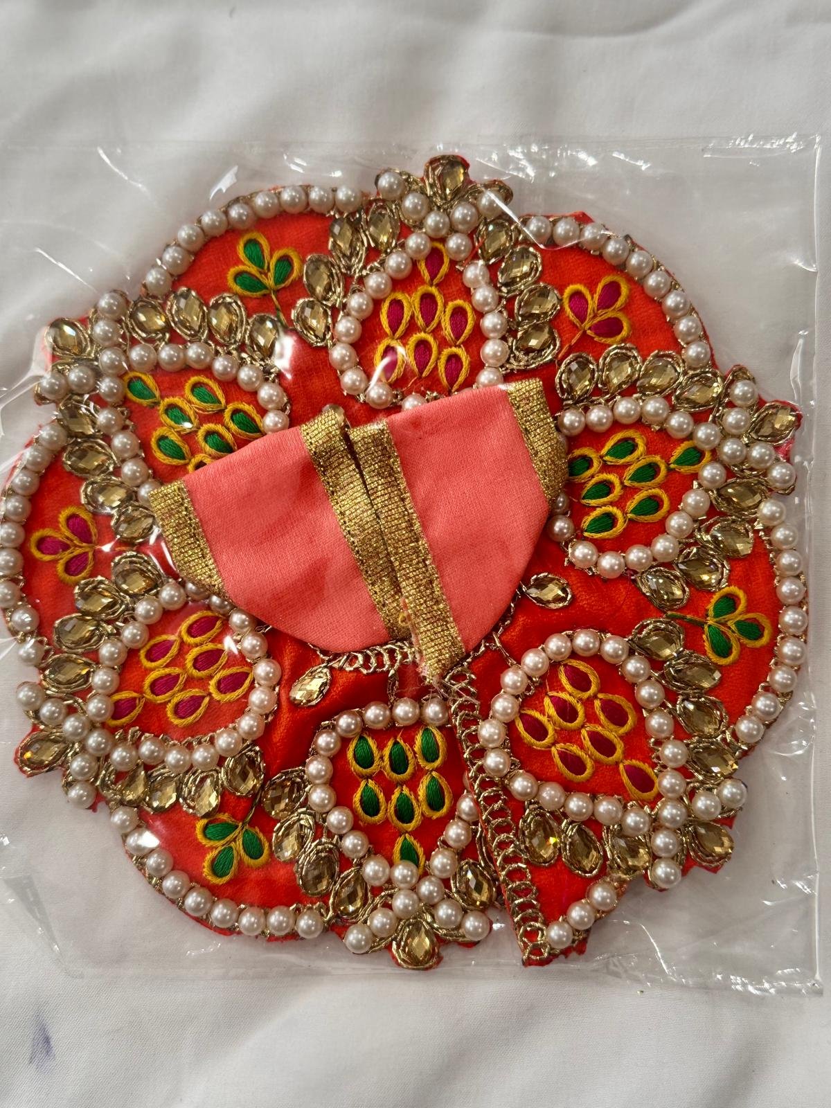 Orange and peach Laddu Gopal dress in Size 2 with pearl beading, golden mirror work, and multicolor embroidery in floral leaf patterns.