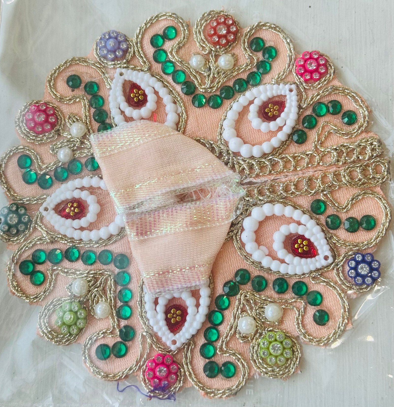 Peach Laddu Gopal dress adorned with white bead paisleys, green stones, and multicolor decorative beads