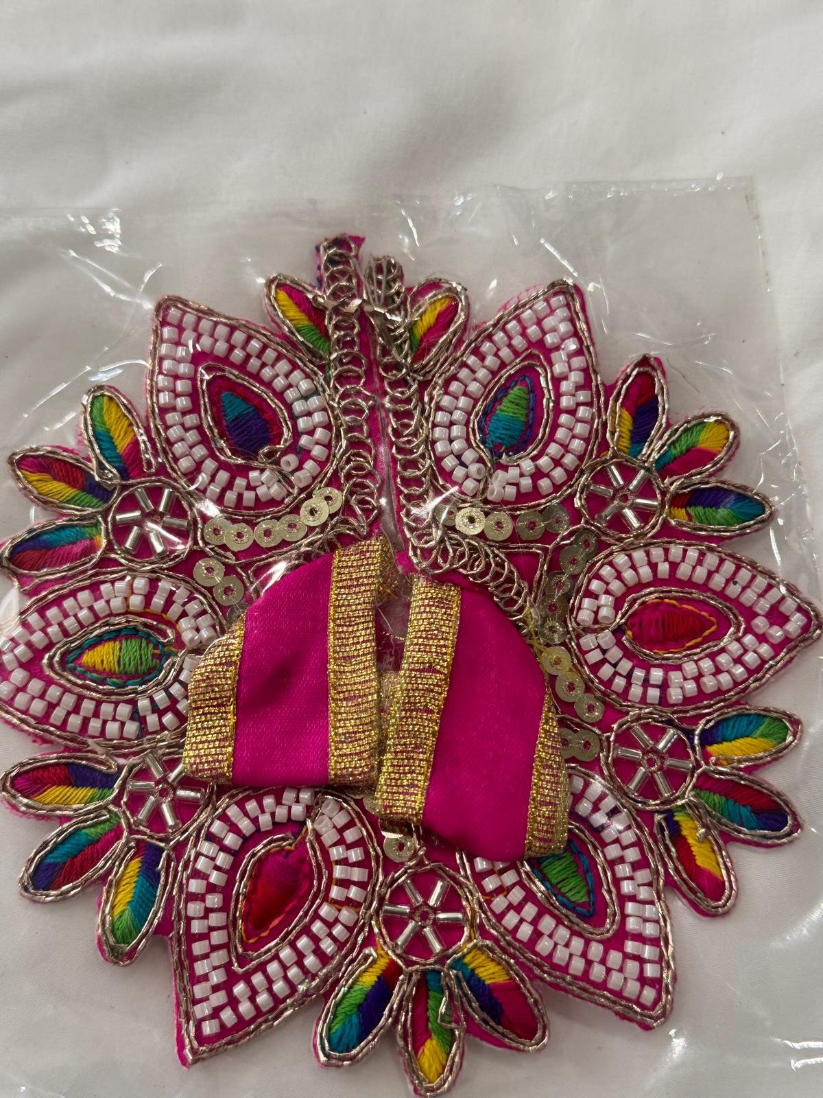 Vibrant pink Laddu Gopal dress with rainbow thread embroidery, white beadwork, and golden gota detailing