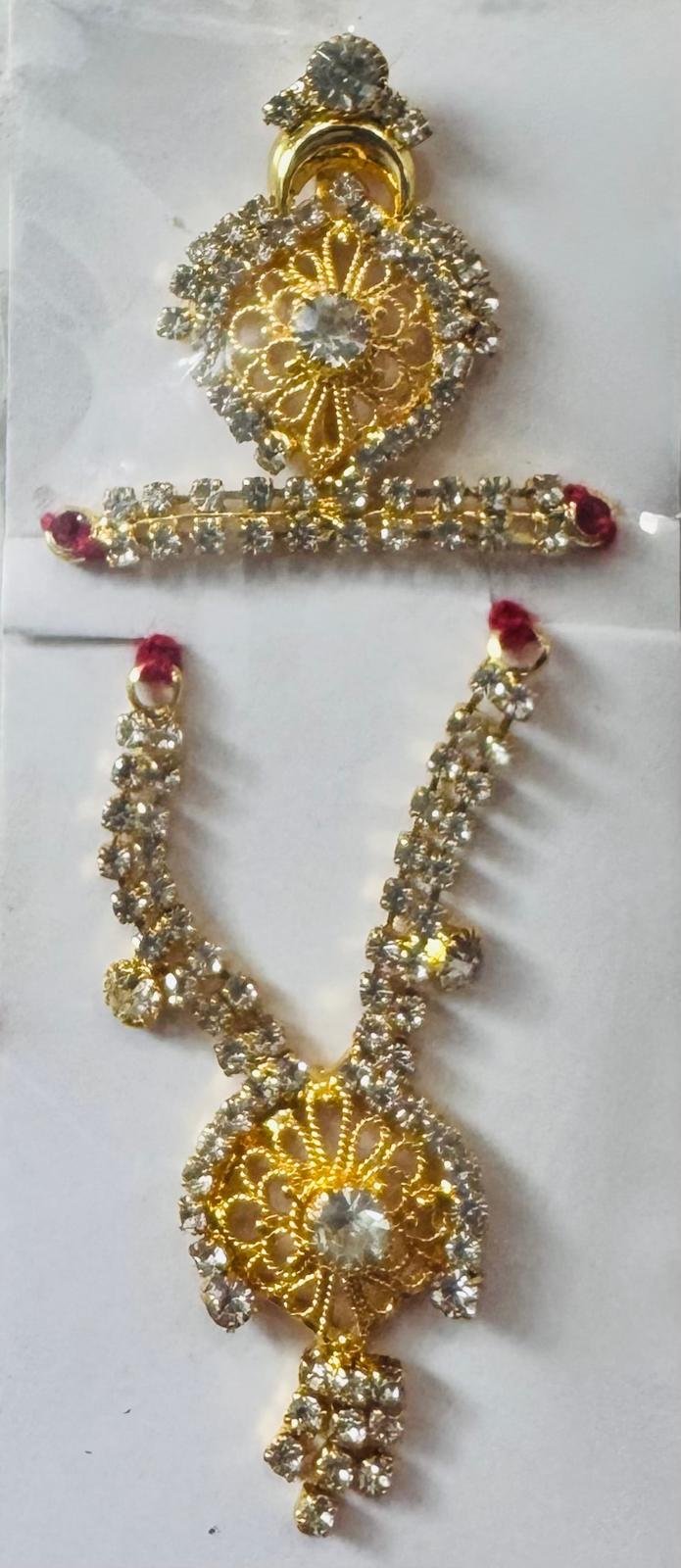 Laddu Gopal accessory set featuring a golden floral filigree mukut and matching necklace adorned with clear rhinestones.