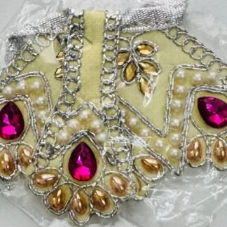 Cream Radha Rani dress with magenta stones, golden pearls, and silver lace embroidery, in clear plastic packaging.