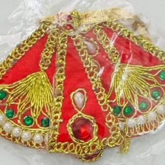 Red Radha Rani dress with gold peacock embroidery, green stones, and pearl detailing, shown inside a transparent plastic wrapper.