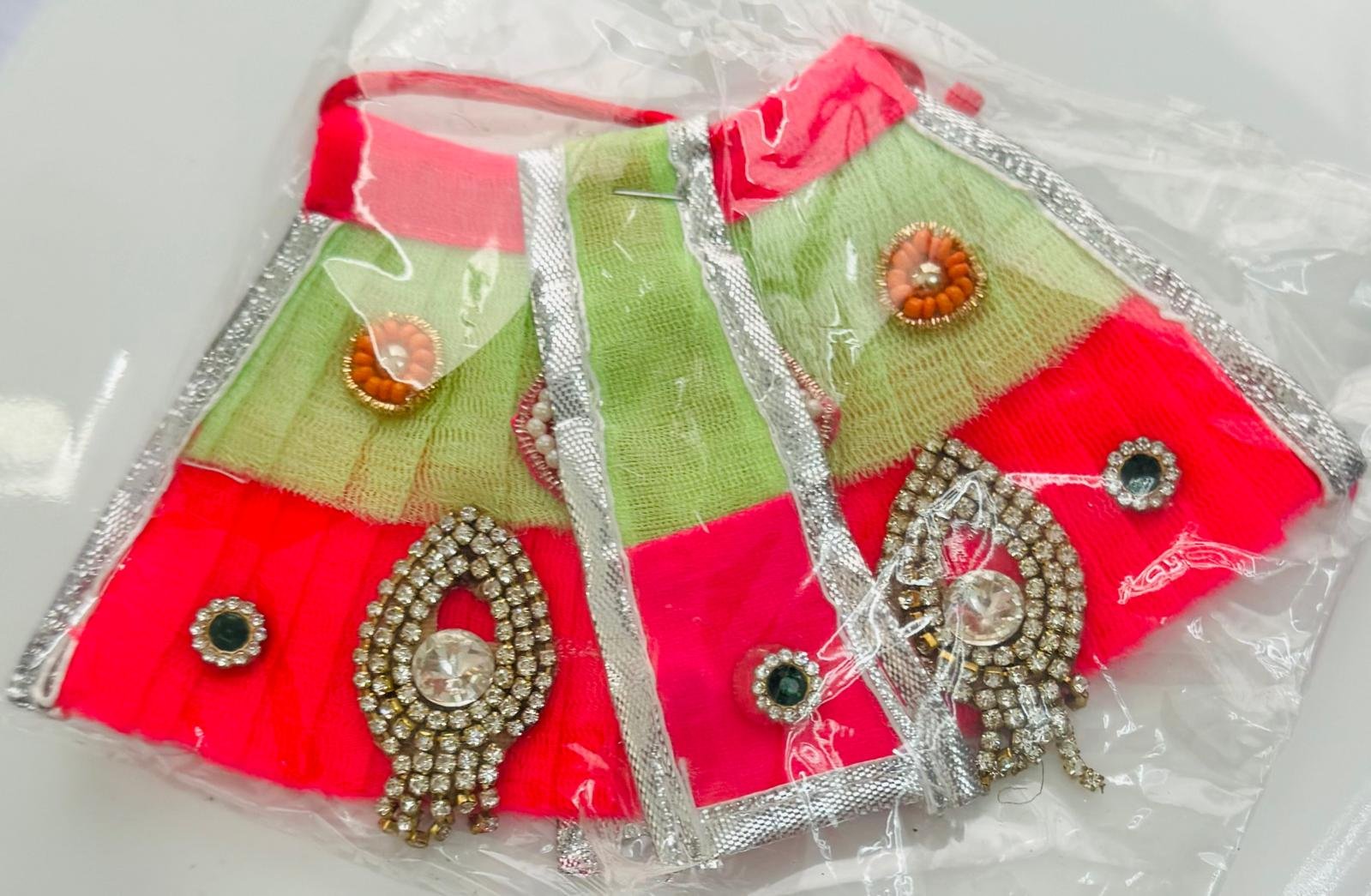 Green and pink net Radha Rani dress with silver border and stone brooch decoration